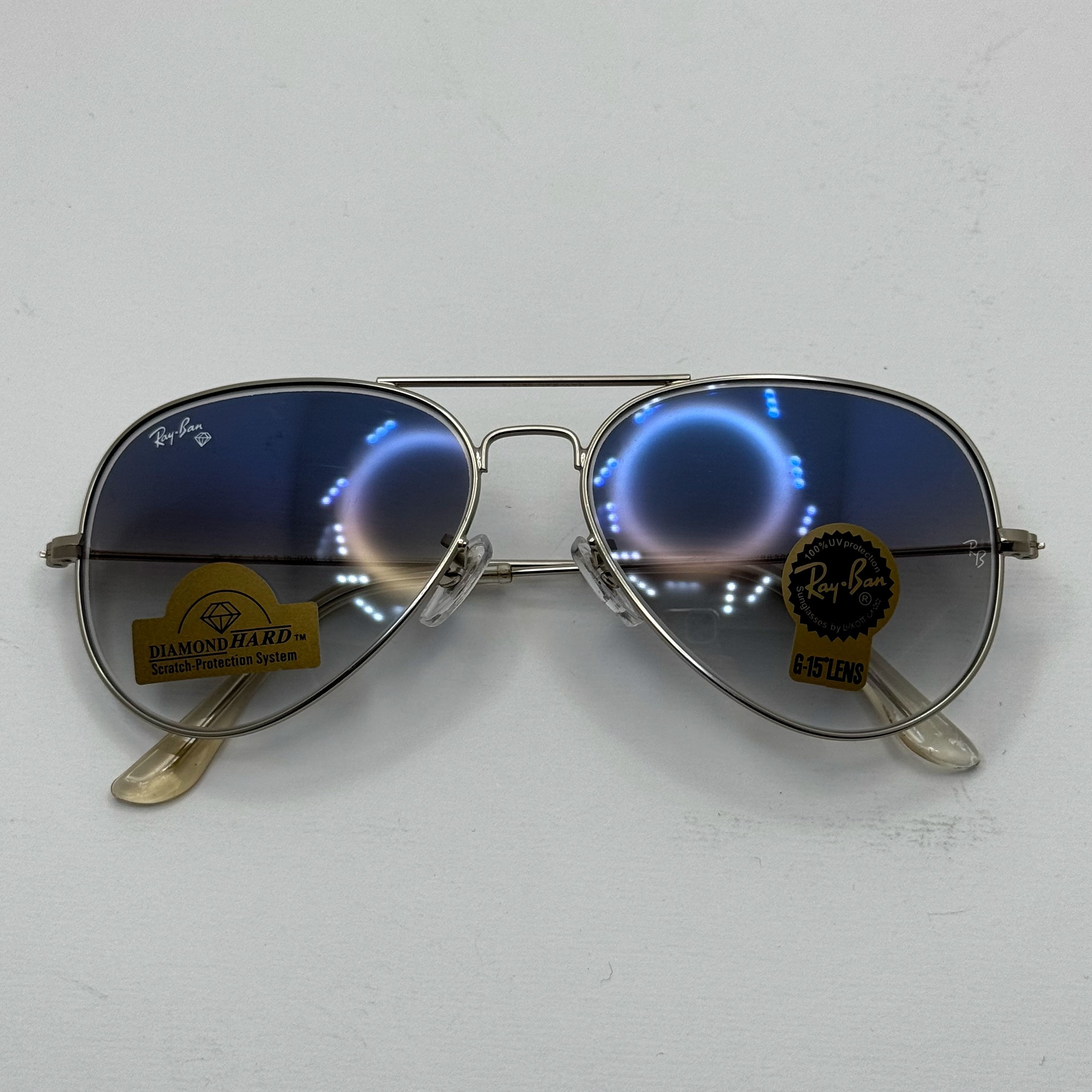 عینک ریبن خلبانی شیشه سنگ آبی هایلایت فریم نقره ای به همراه پک کامل ریبن کد Rayban RB 3025