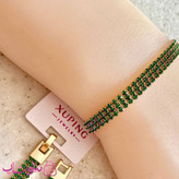 دستبند دخترانه ژوپینگ طرح تنیسی سبز طلایی سه لاین کد 5491